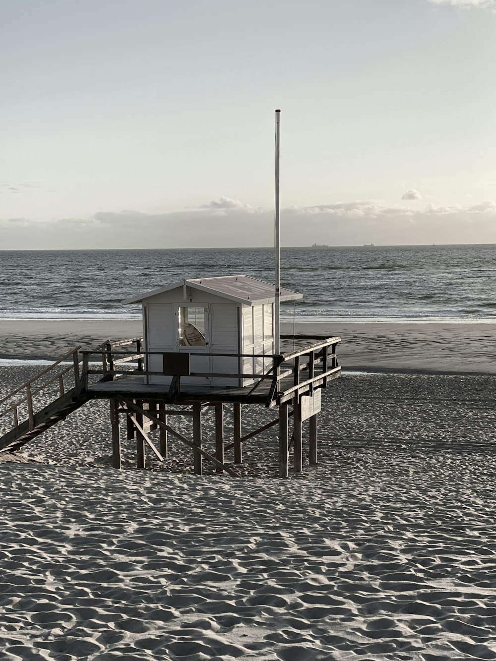 white wooden lifeguard house on beach during daytime