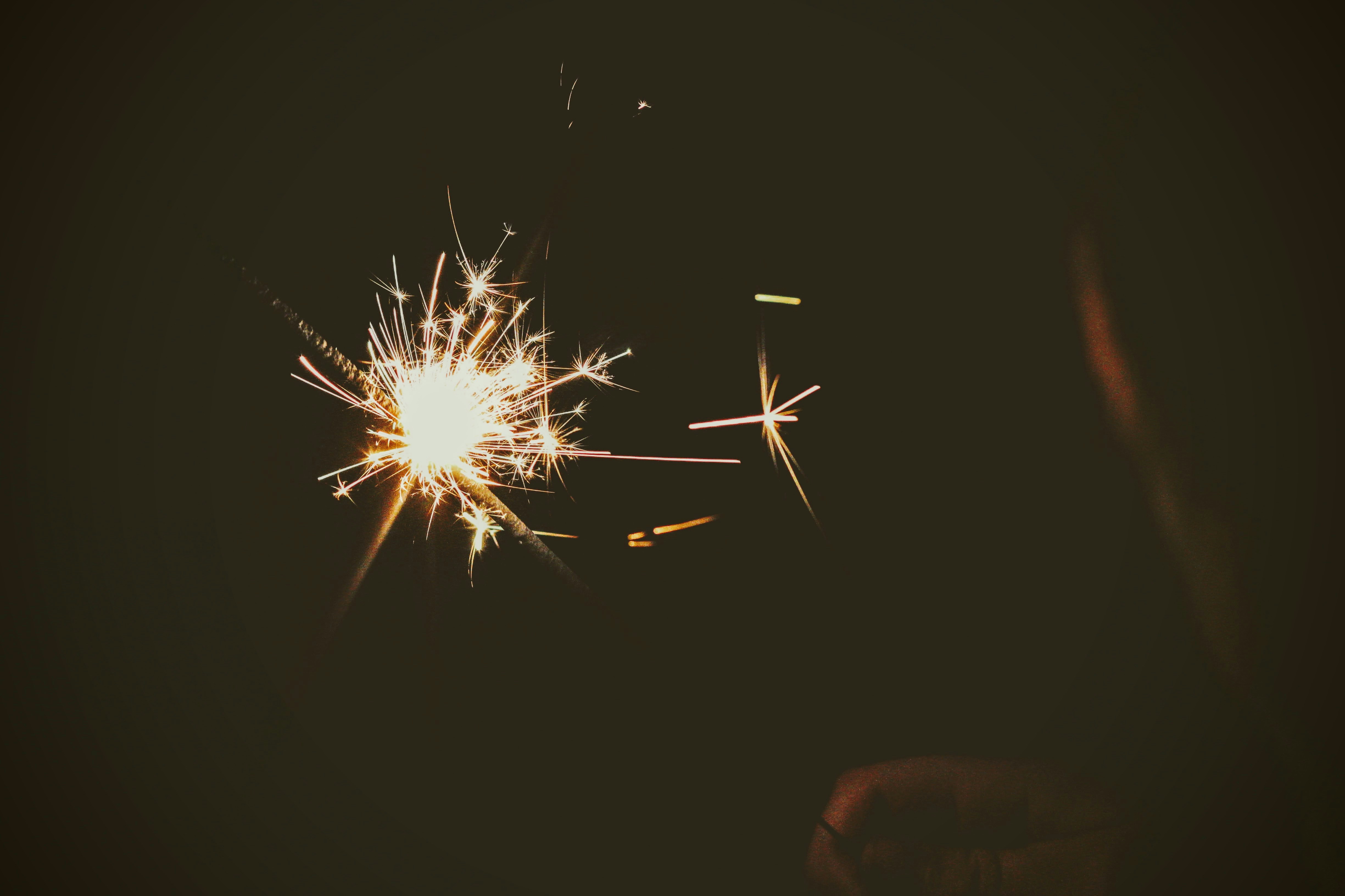 person holding white sparkler during nighttime