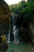 people standing near waterfalls during daytime