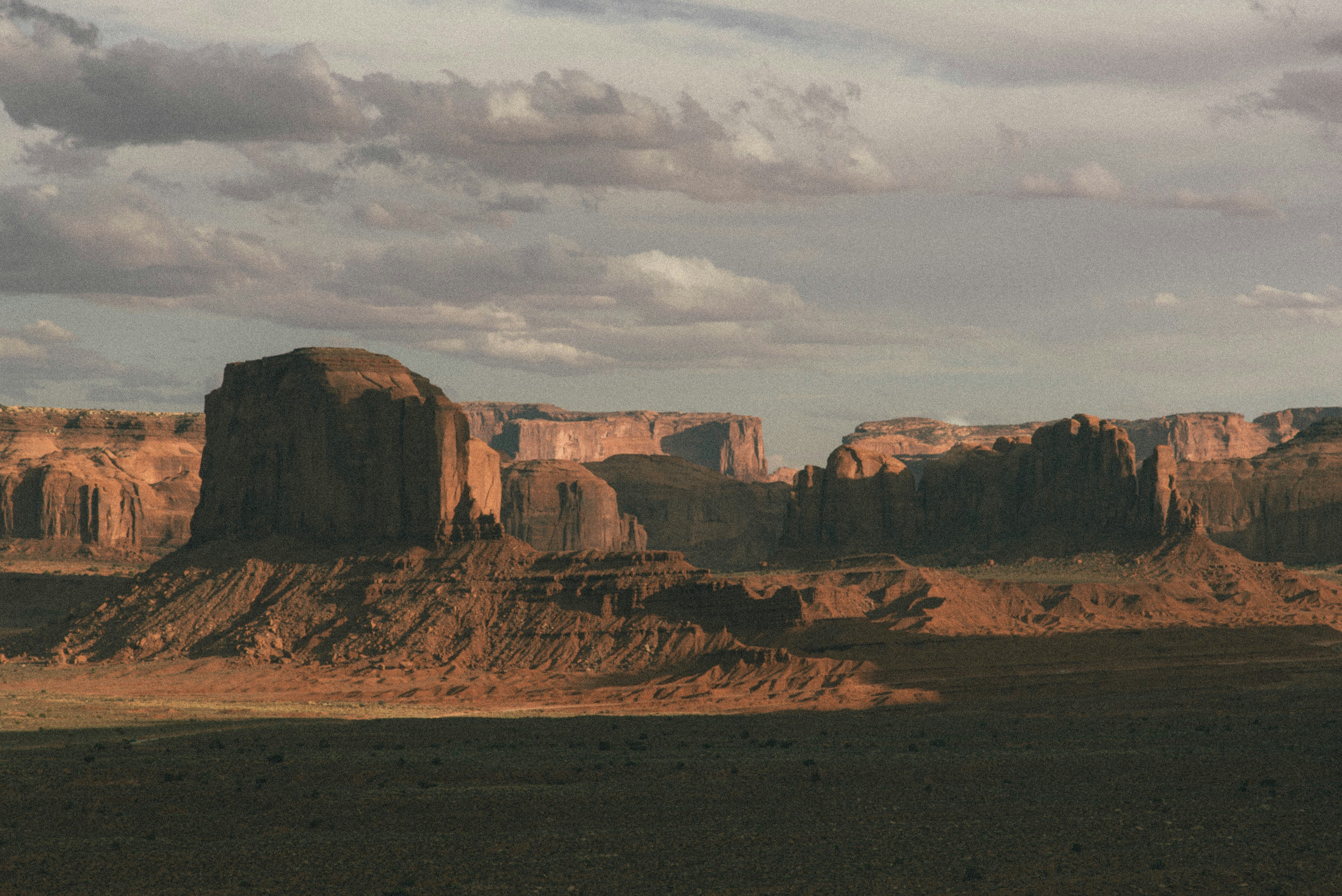 Braune Felsformation unter weißen Wolken tagsüber