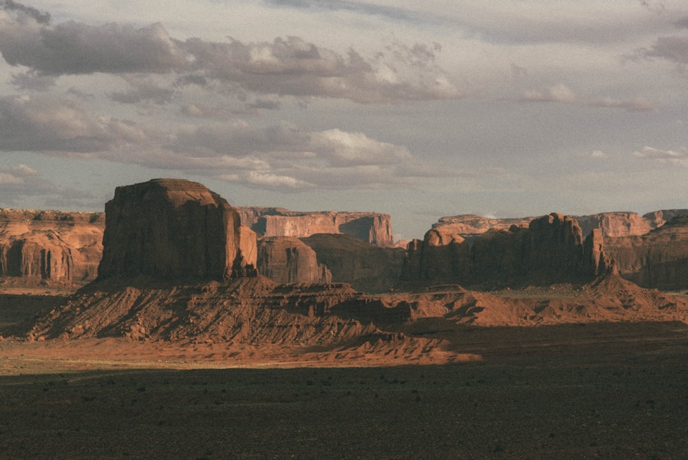 brown rock formation under white clouds during daytime