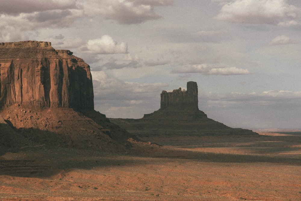 brown rock formation under white clouds during daytime