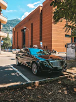 Sleek black Mercedes-Benz S-Class parked in an elegant urban setting at dusk.