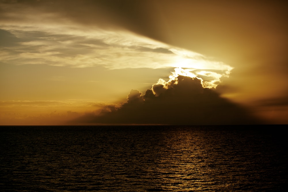 body of water under cloudy sky during sunset