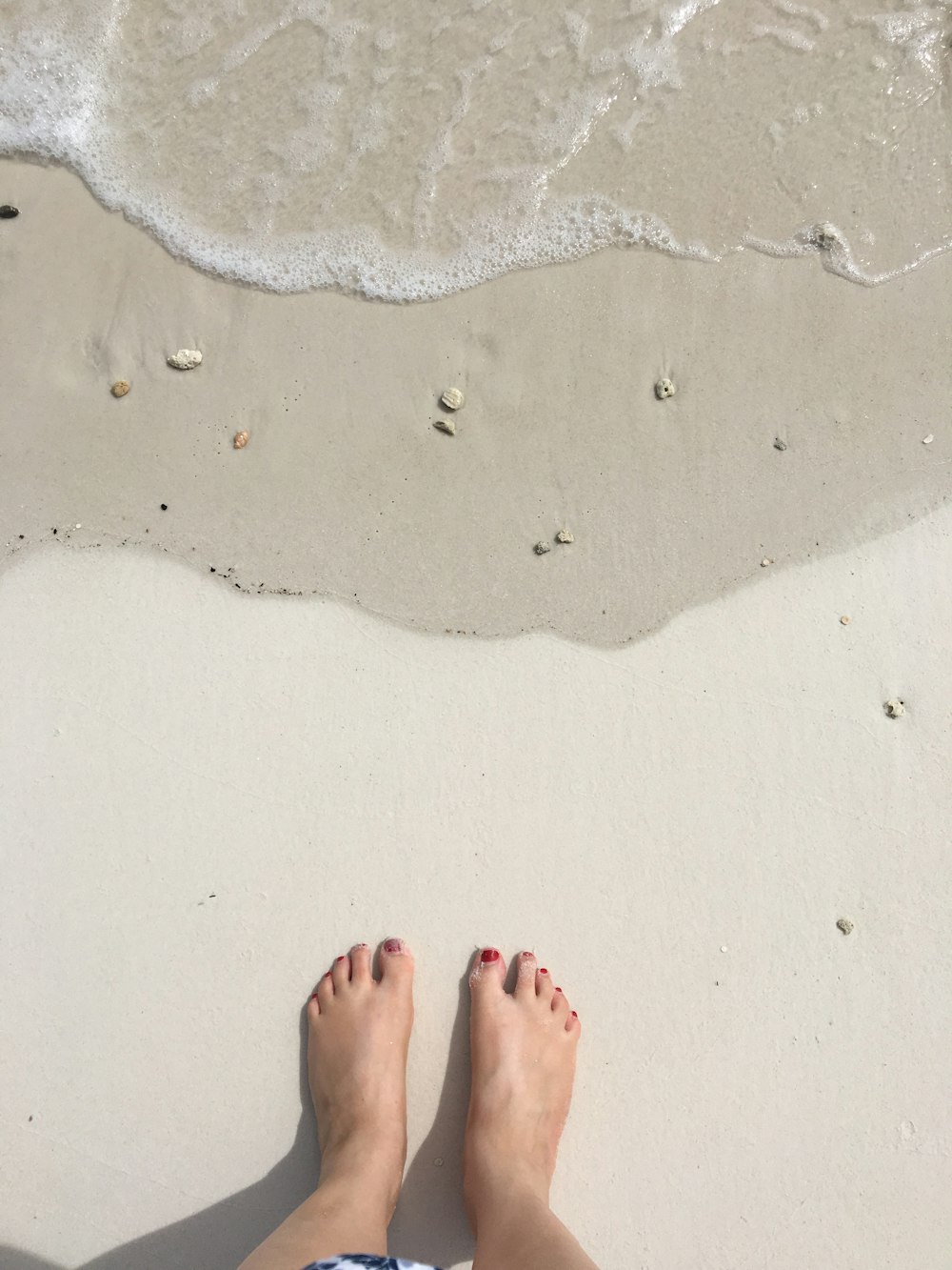 person standing on white sand beach during daytime