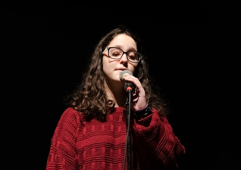 woman in red and black plaid dress shirt singing