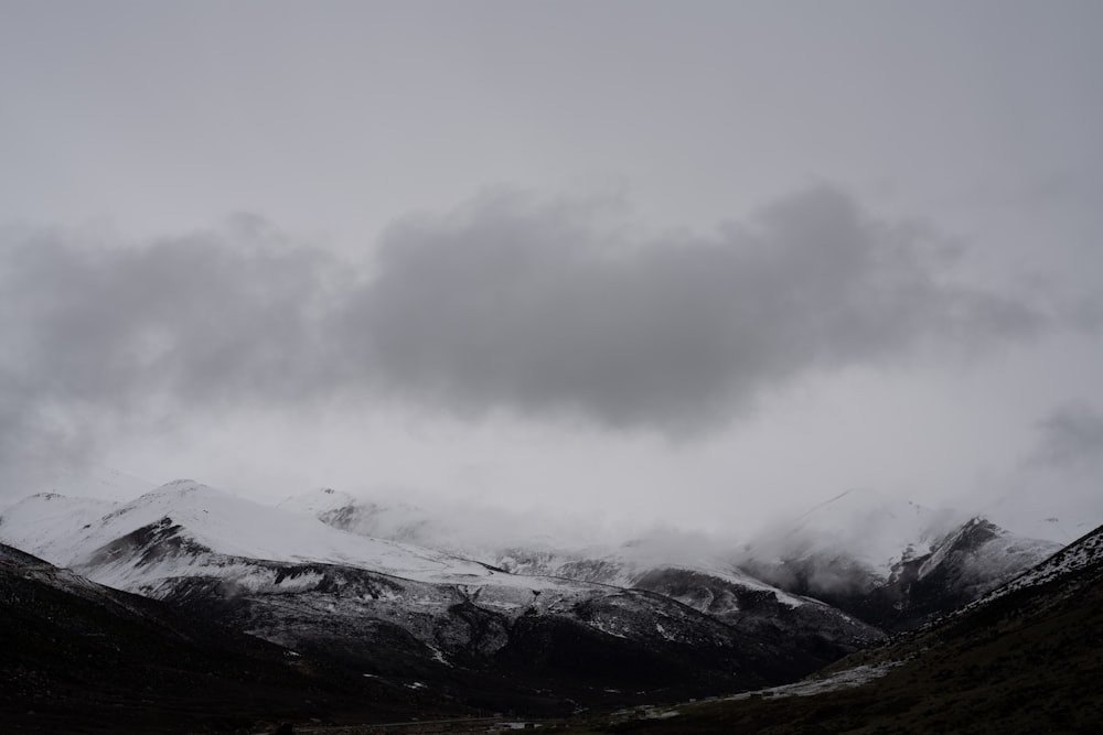 black and white mountain under white clouds