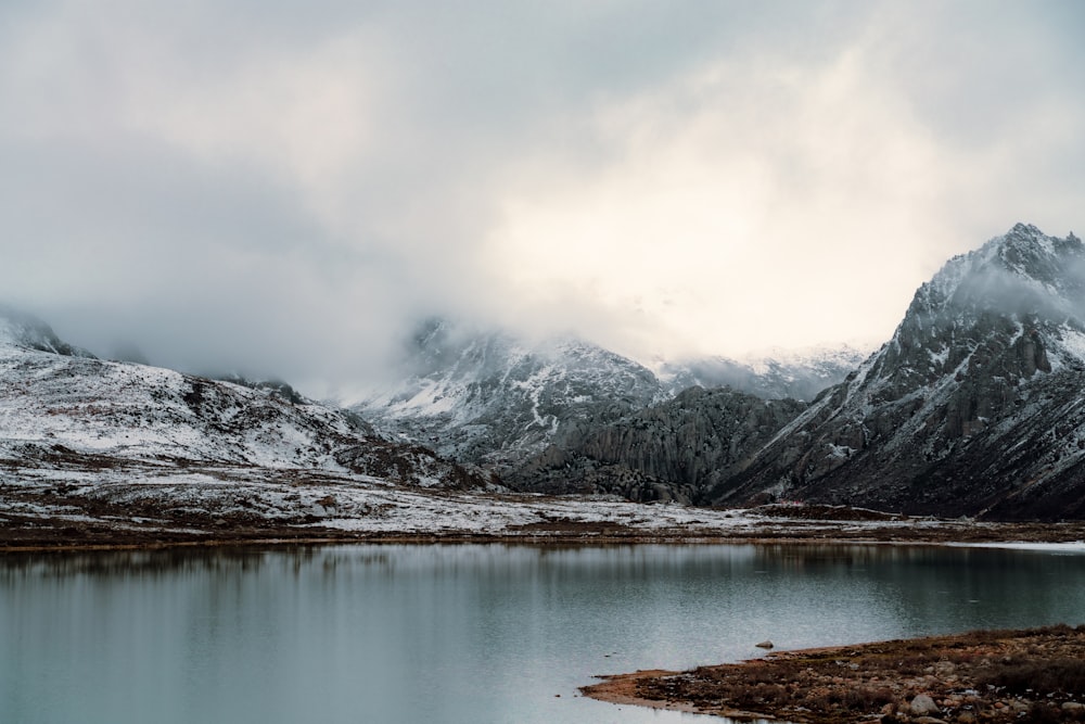 snow covered mountain near lake during daytime