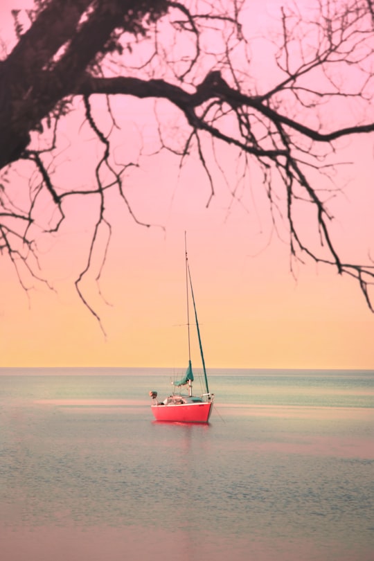 red boat on beach during sunset in Humber Bay Canada