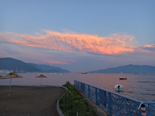 Sunset view over the calm sea with colorful boats anchored near Canasvieiras shore