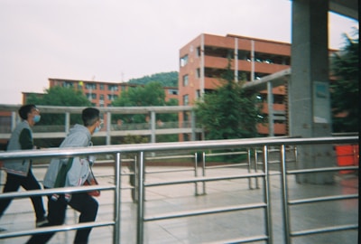 man in white shirt and black pants walking on sidewalk