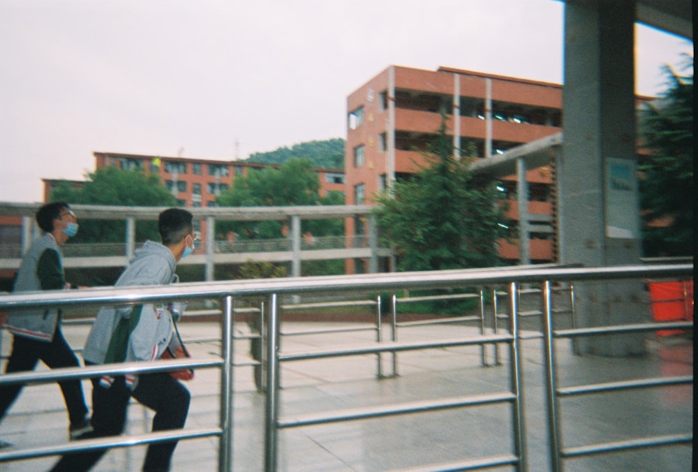 man in white shirt and black pants walking on sidewalk