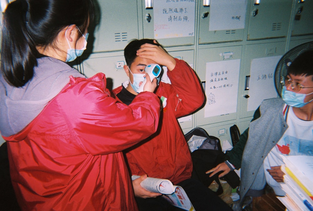 woman in red jacket holding white ceramic mug