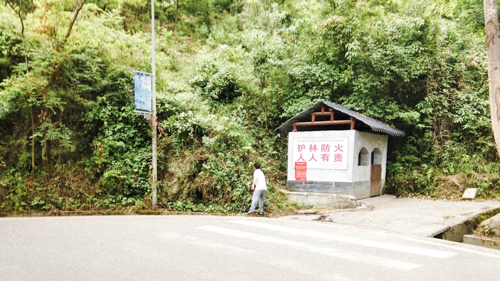 man in white shirt walking on sidewalk during daytime