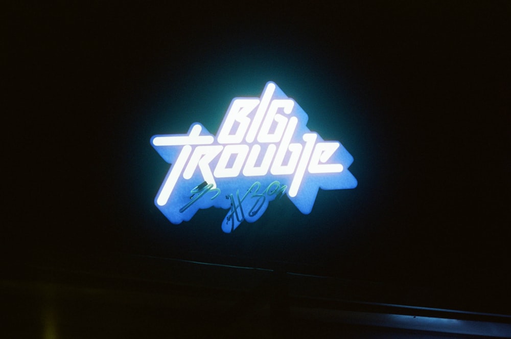 a neon sign that says big trouble on it