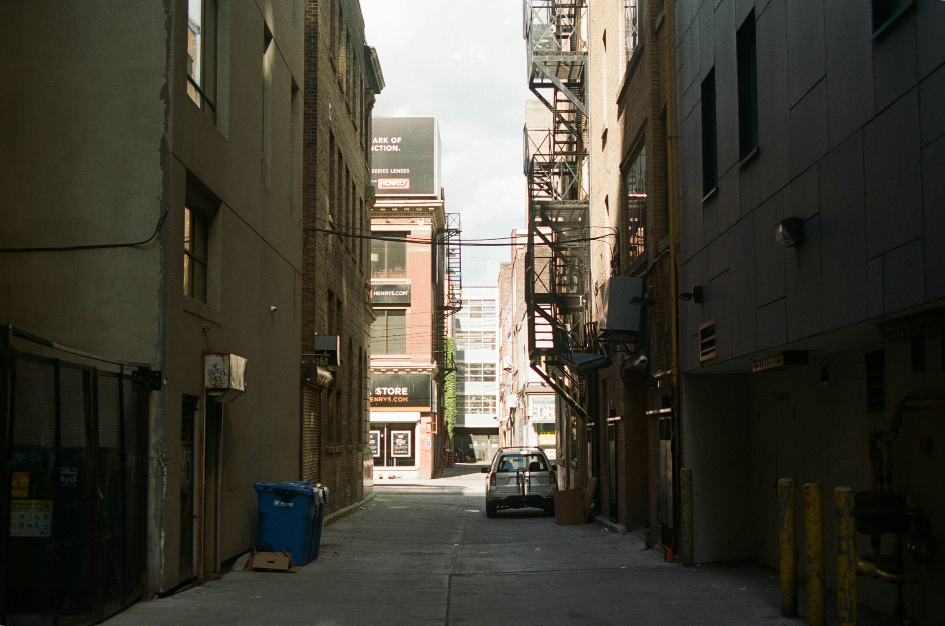 blue trash bin on sidewalk