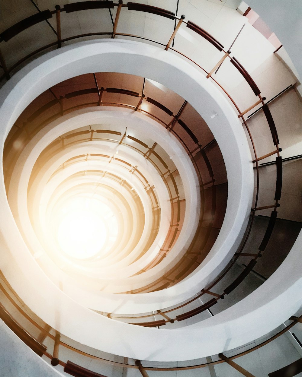 white spiral staircase with brown wooden railings