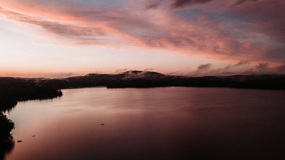 corpo d'acqua vicino alla montagna durante il tramonto