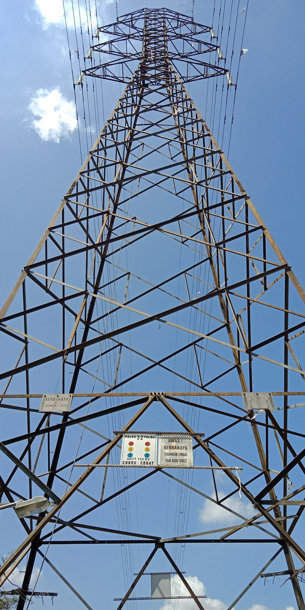 uma torre de metal alta com muitos fios acima dela