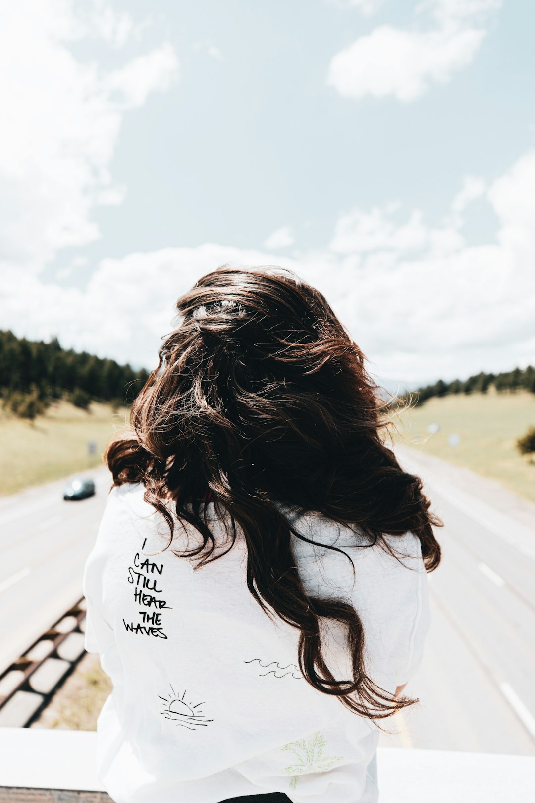 woman in white shirt standing on road during daytime