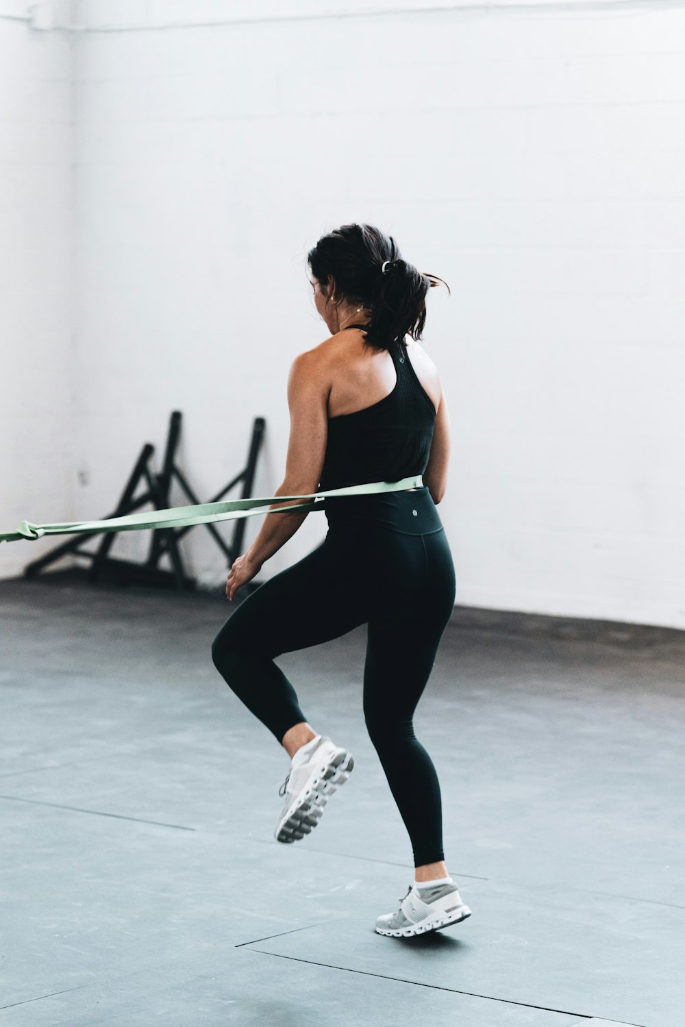 mujer con camiseta sin mangas negra y leggings haciendo ejercicio