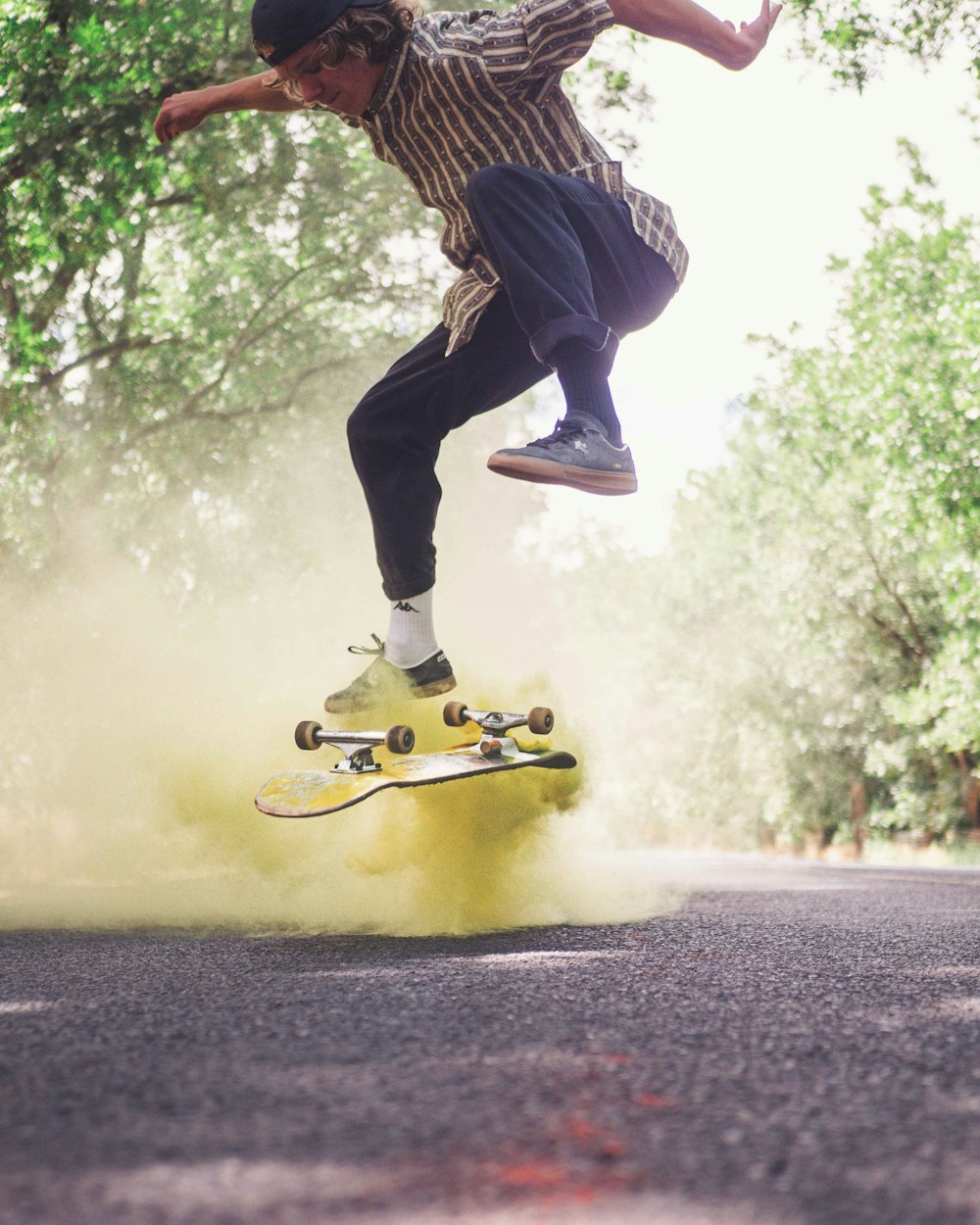 person in black pants and black and white striped shirt jumping on road during daytime