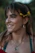 woman in blue tank top with yellow flower on ear smiling