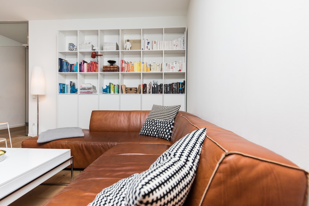 brown leather couch with throw pillows