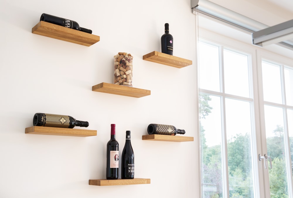 wine bottles on brown wooden wall rack