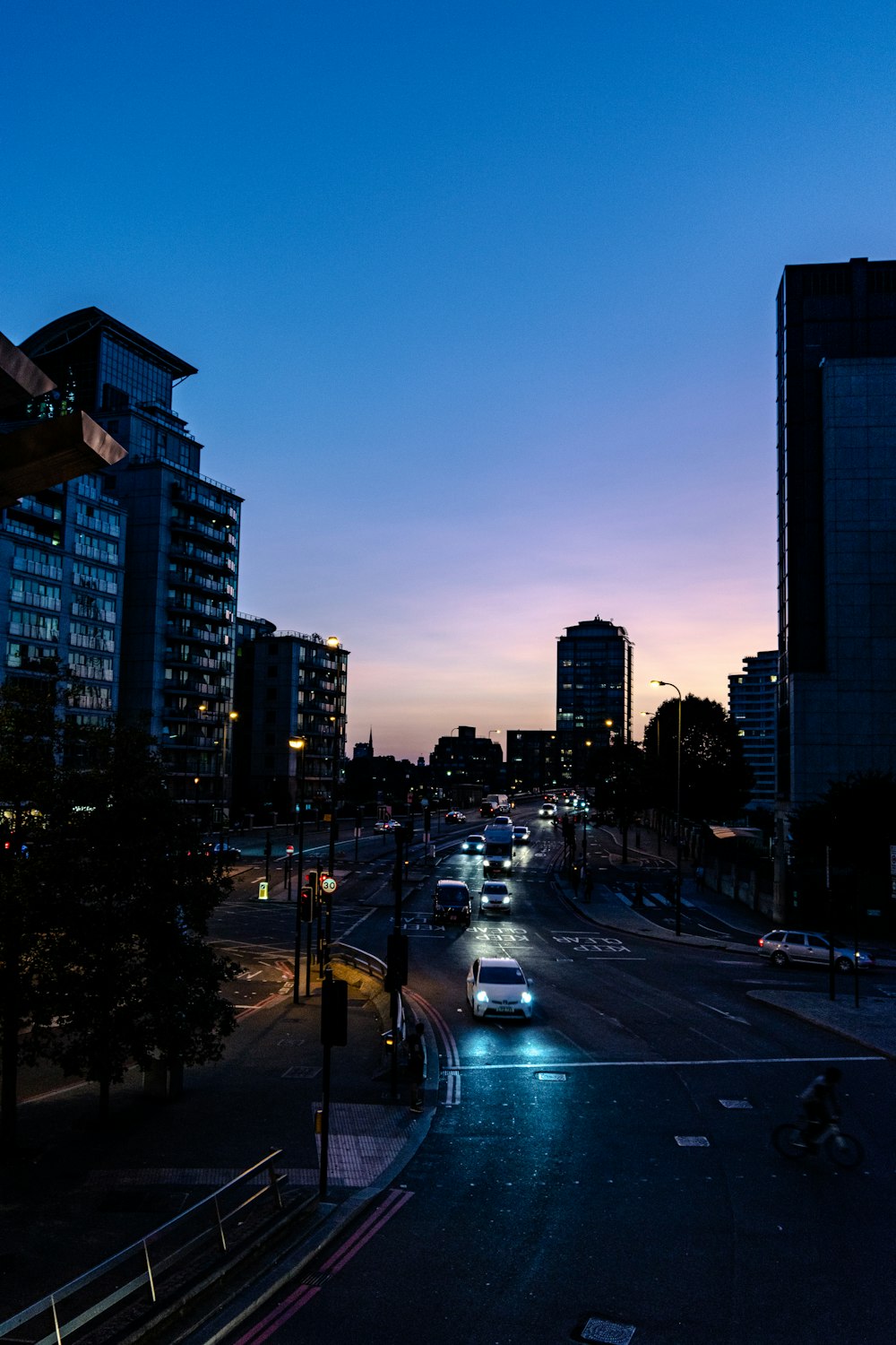 cars on road near high rise buildings during night time