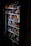 A vending machine filled with various snacks and beverages, including chips, chocolate bars, and canned drinks. The machine is dimly lit, highlighting the items inside through the clear glass panel.