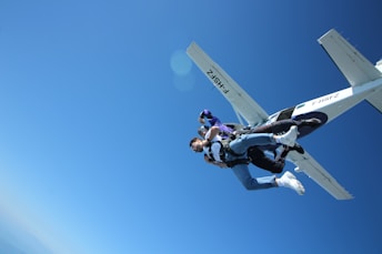 man in black and white jacket and black pants riding white and black skateboard during daytime