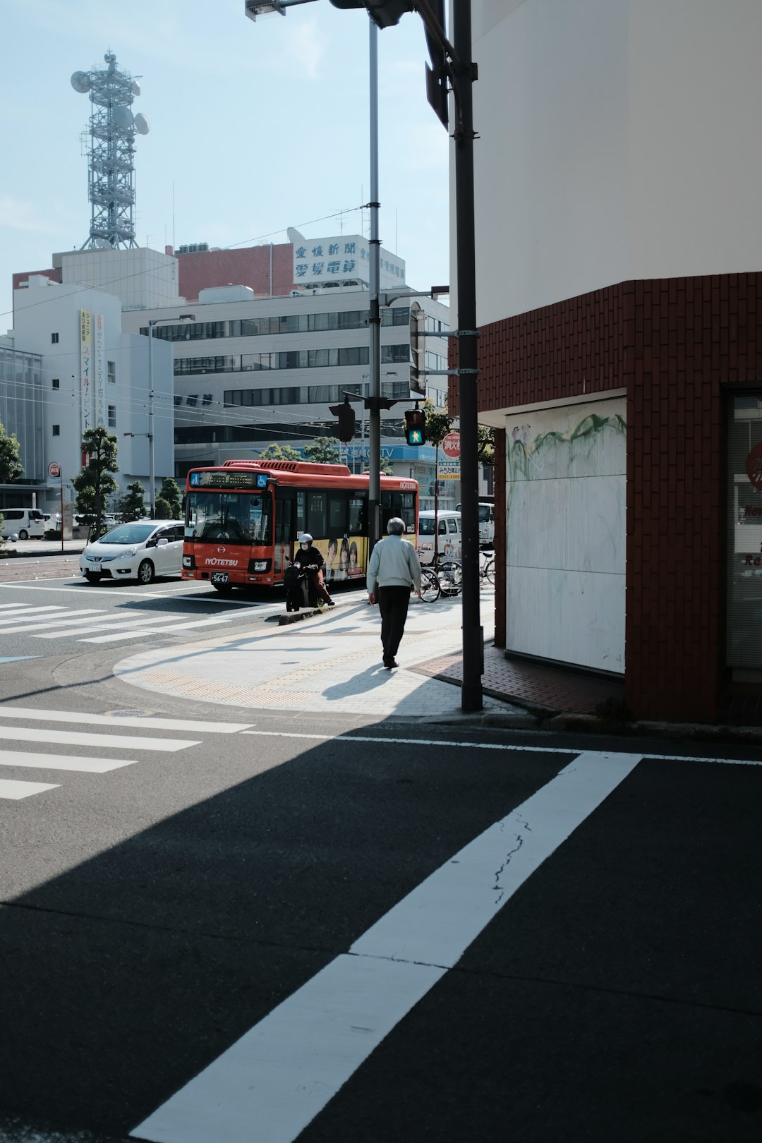 red bus on road near brown building during daytime