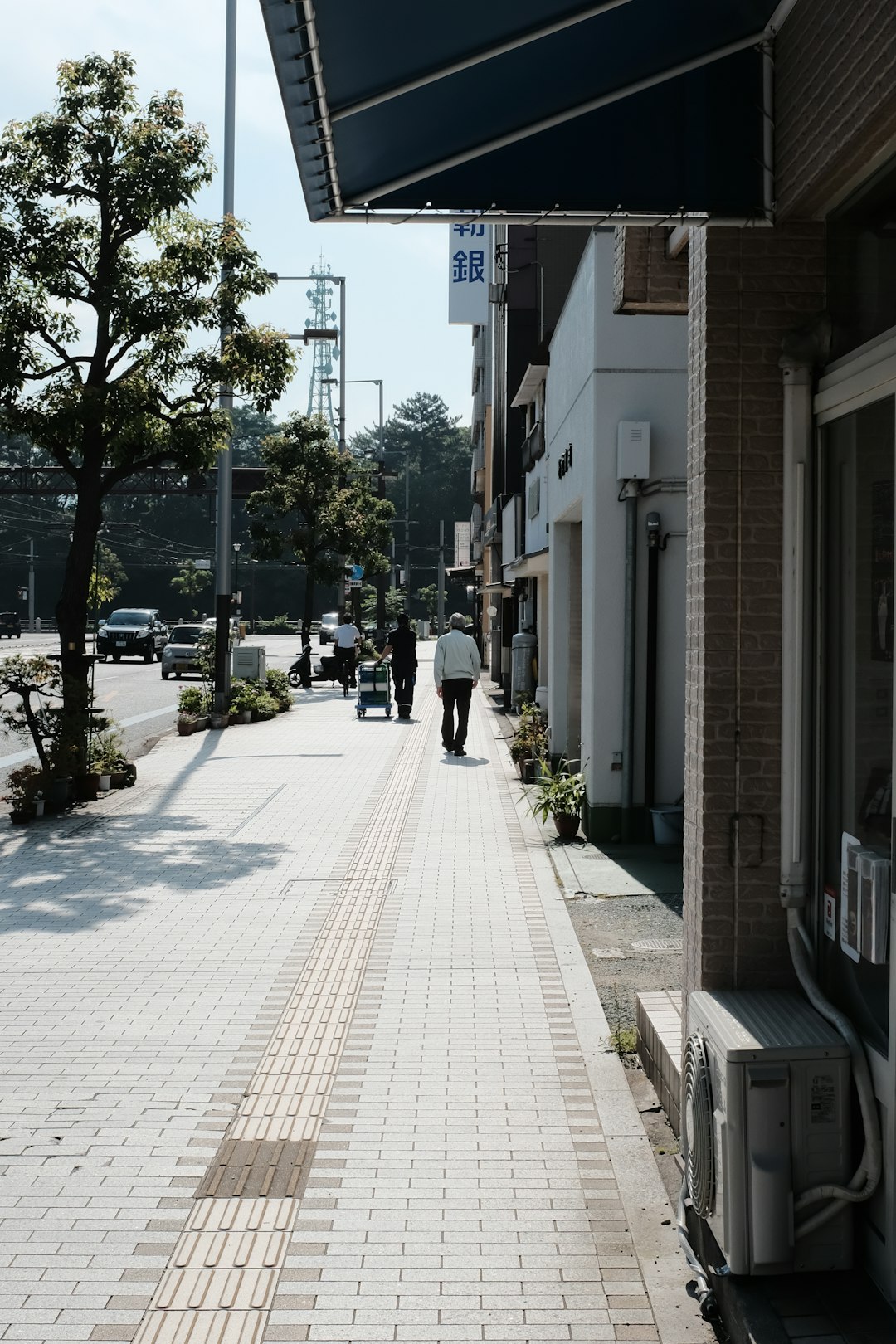 people walking on sidewalk near building during daytime