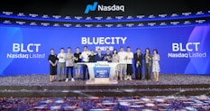 A group of people standing on a stage during a Nasdaq listing ceremony. The background features large digital screens displaying 'Bluecity' and ticker symbols such as 'BLCT'. Confetti is scattered on the floor, indicating a celebratory event.