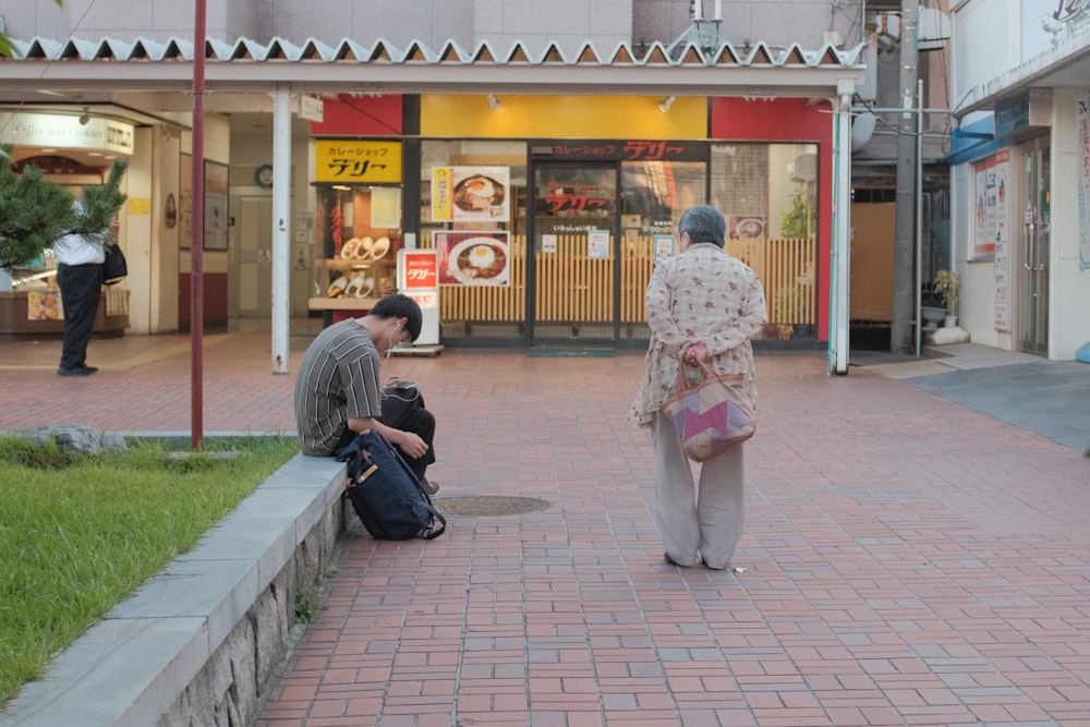 woman in pink and white long sleeve shirt and black backpack walking on sidewalk during daytime