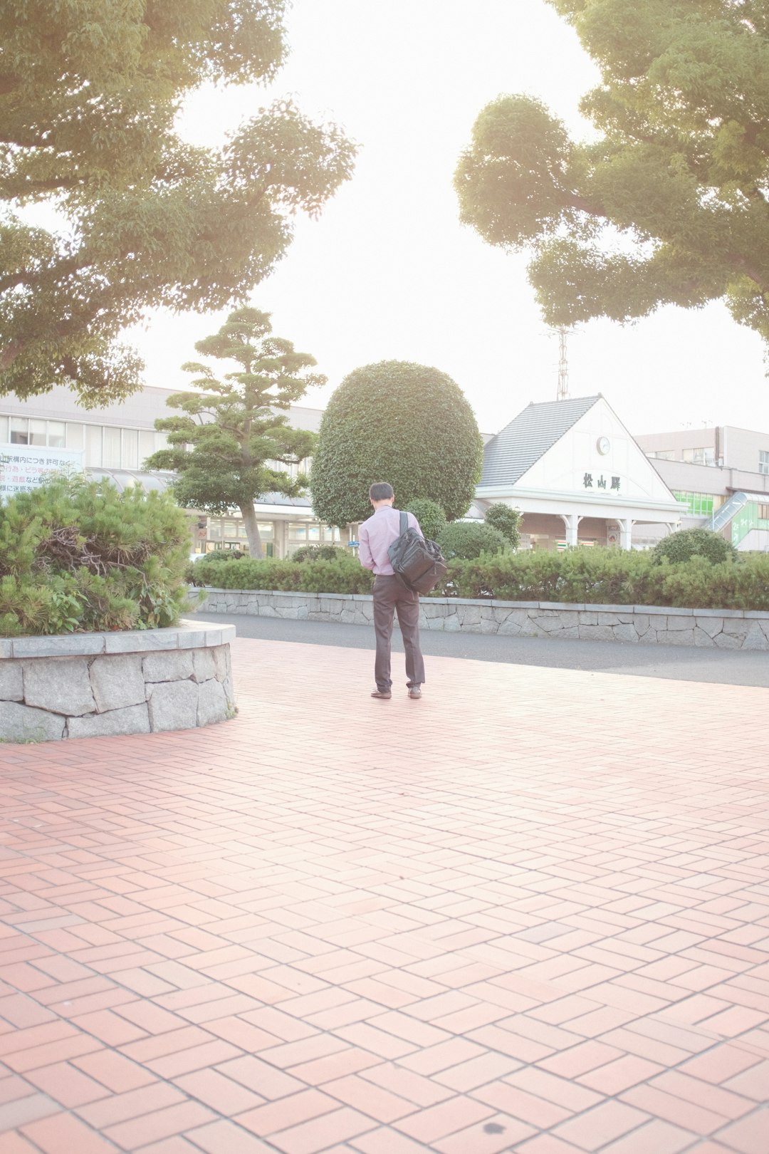 man in green jacket walking on sidewalk during daytime