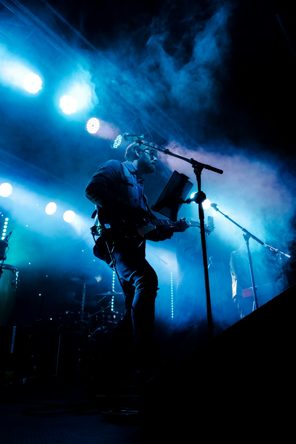 man in black jacket singing on stage