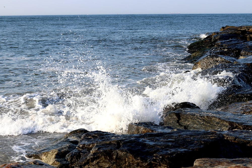 ocean waves crashing on brown rock