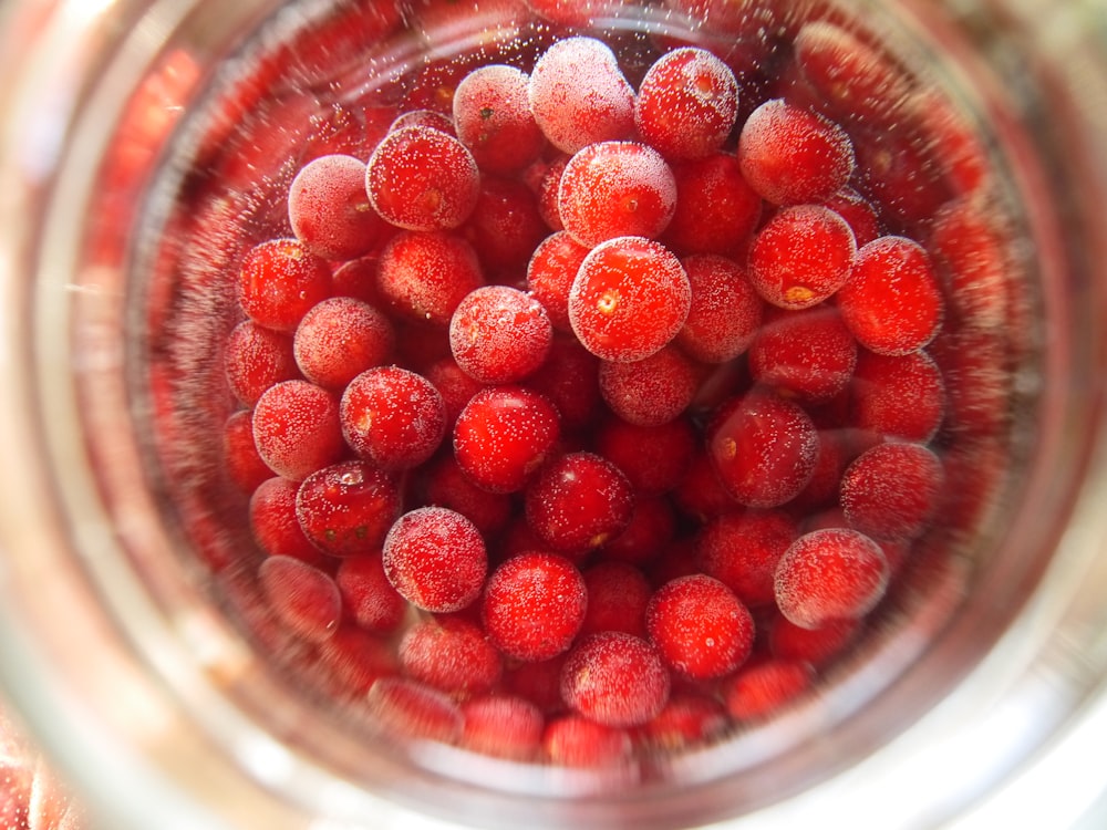 red round fruits in clear glass bowl