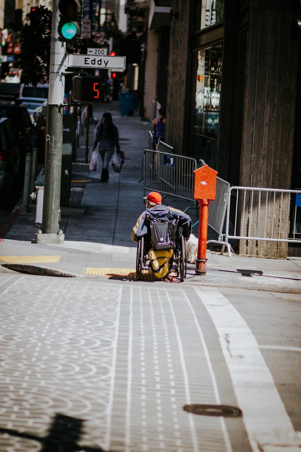 man in black jacket and black backpack walking on sidewalk during daytime