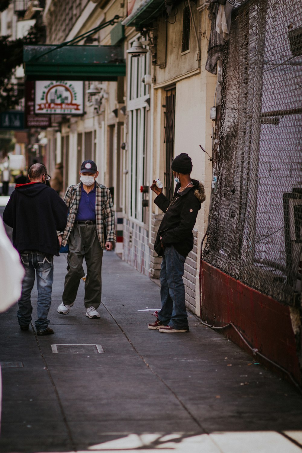 man in black jacket walking on sidewalk during daytime