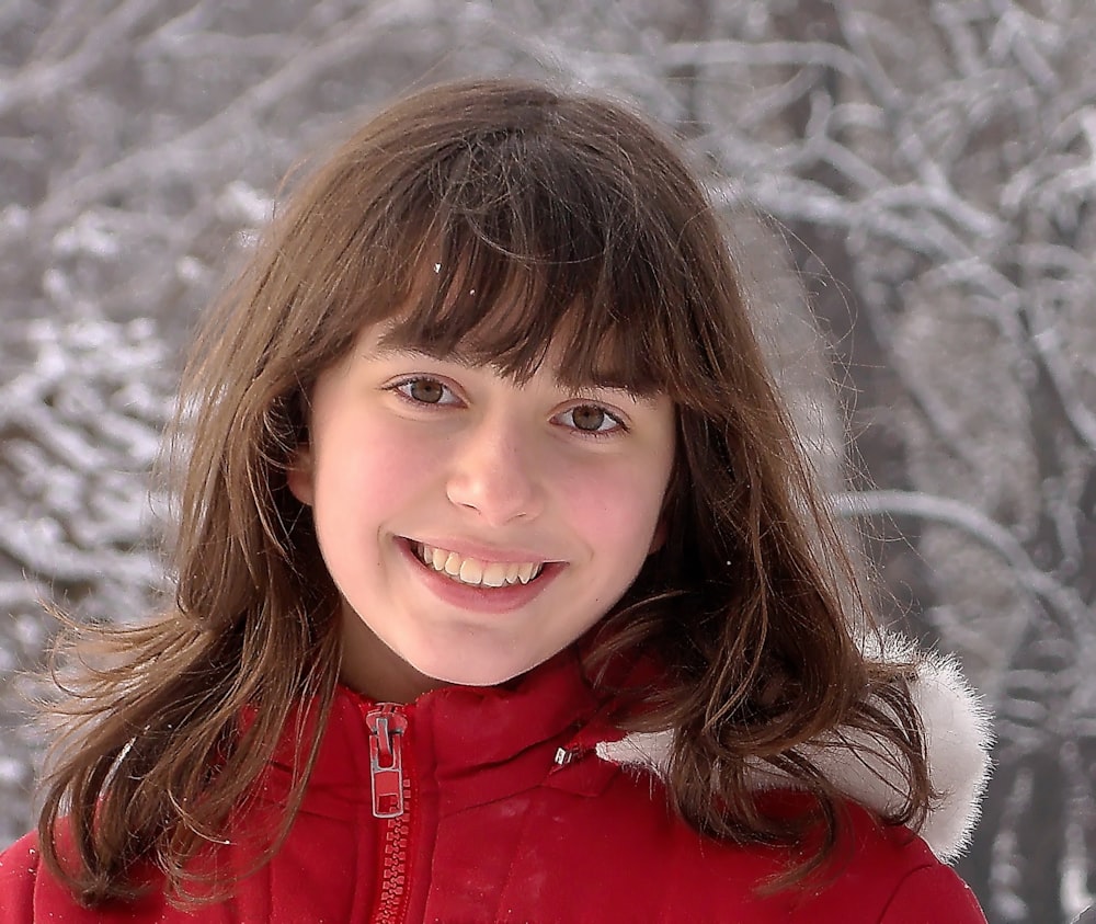 girl in red zip up jacket smiling