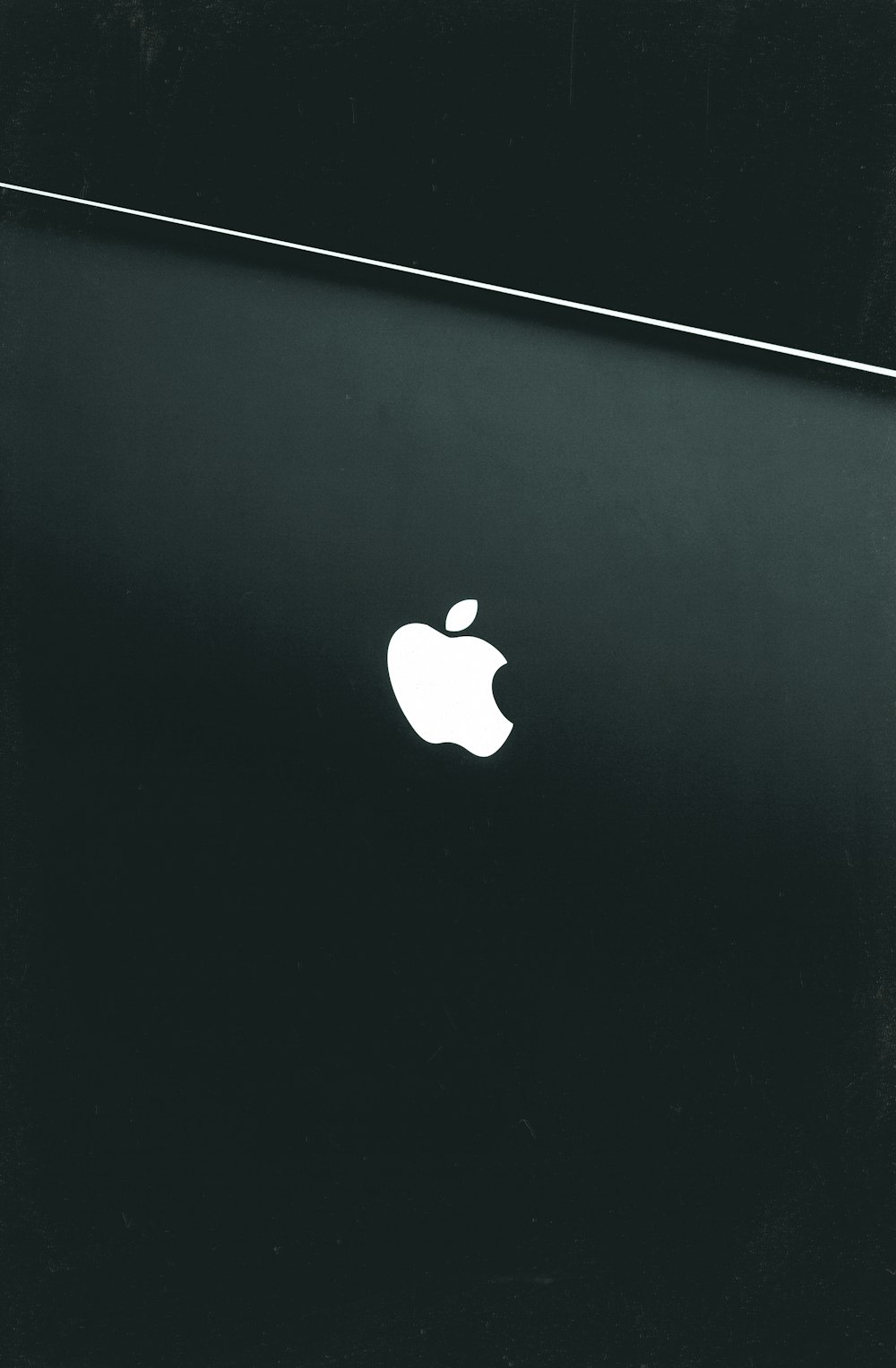 silver macbook on black table