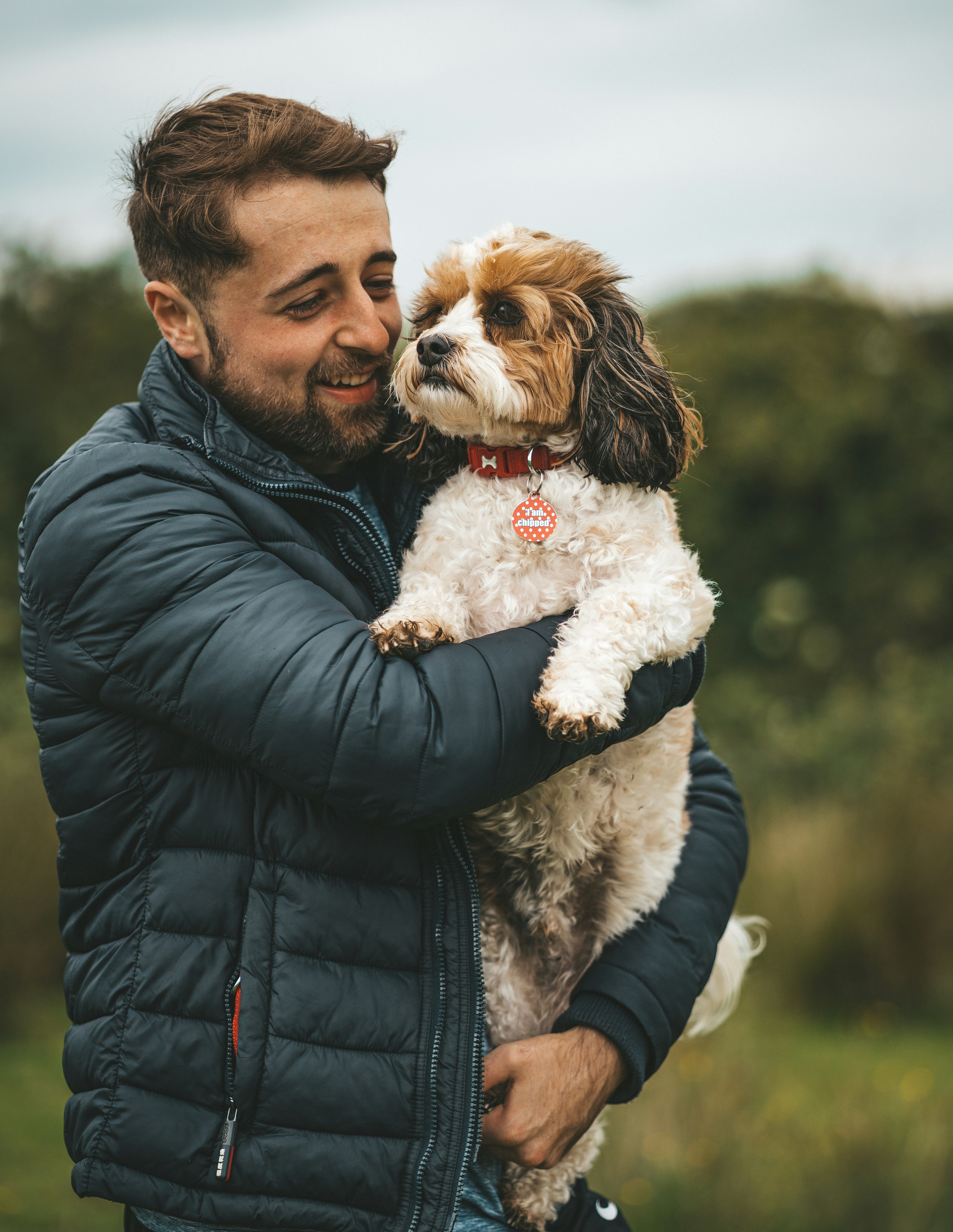 great photo recipe,how to photograph man’s best friend ; man in black leather jacket holding white and brown long coated small dog