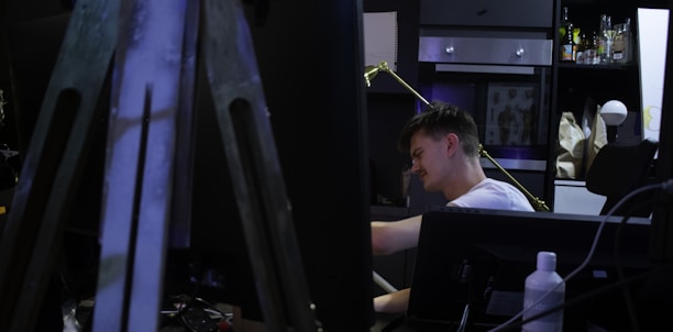 Portrait of Djamee Raphaël working thoughtfully at his creative studio desk.