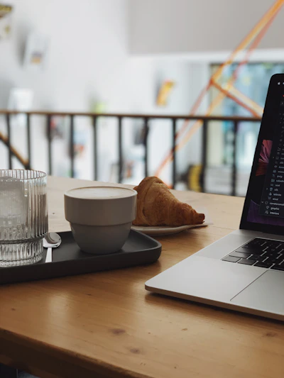 A cozy workspace with a laptop, notebook, and coffee cup, showing a freelancer in action.