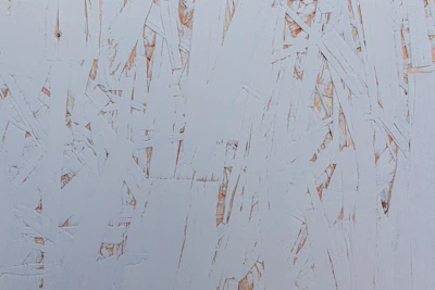 Close-up of a white PVA adhesive being applied to a wooden surface.