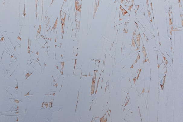 Close-up of textured surfaces combining wood, metal, and paint, highlighting the tactile quality of the work.