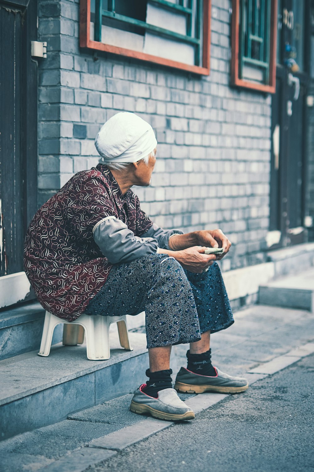 woman in white hijab sitting on gray concrete bench